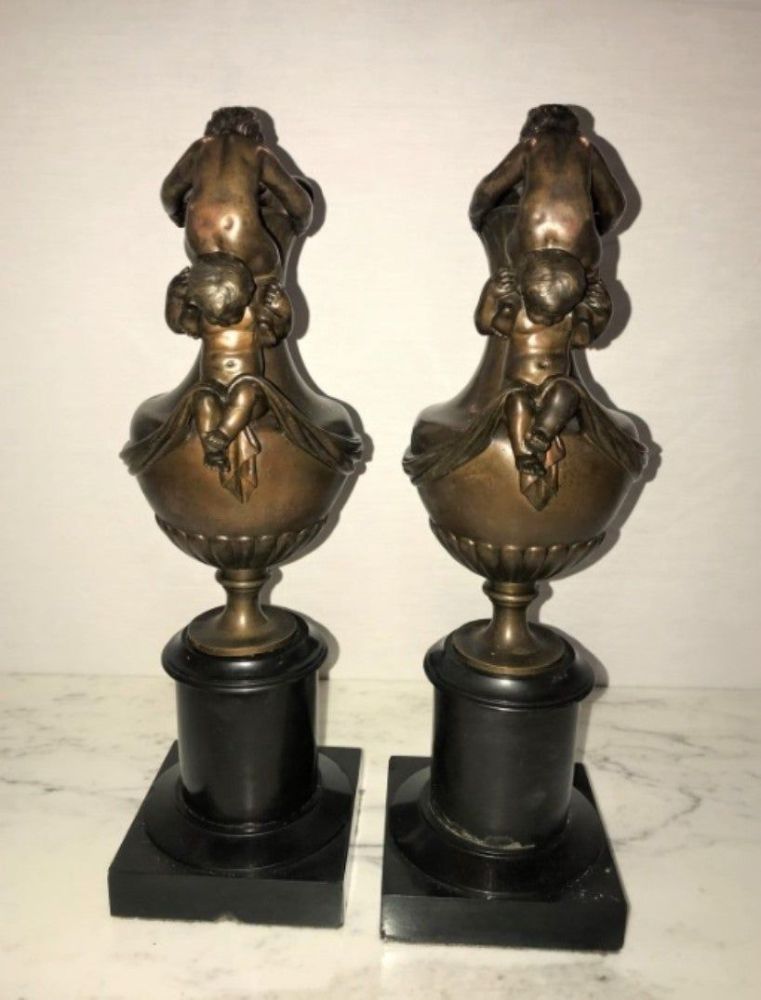 Pair of 19th Century Urns on Marble Stands Bearing Cherubs and Rams Heads