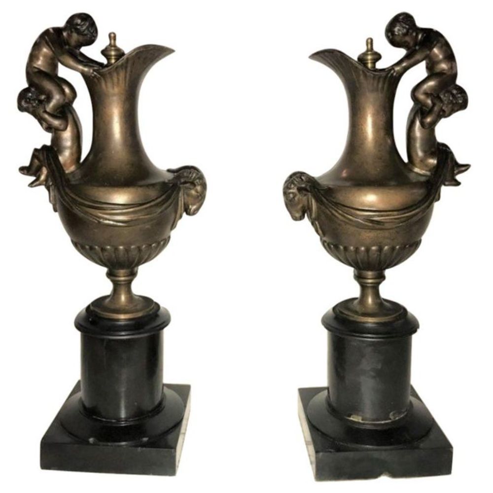 Pair of 19th Century Urns on Marble Stands Bearing Cherubs and Rams Heads